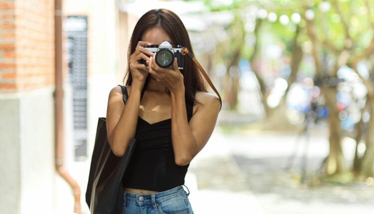 Young girl holds camera up to her face.