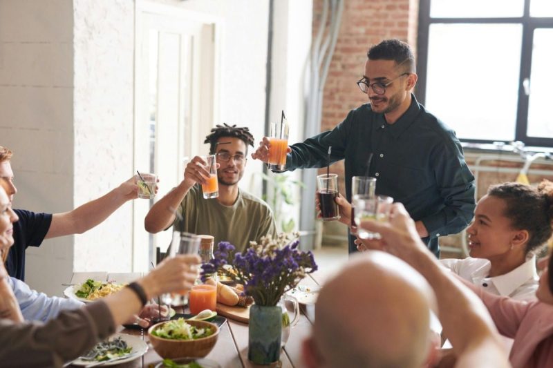 Group of people celebrating Thanksgiving together at the dinner table.