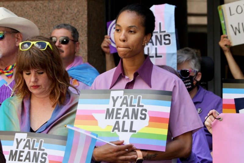 Person holding Y'all Means All sign