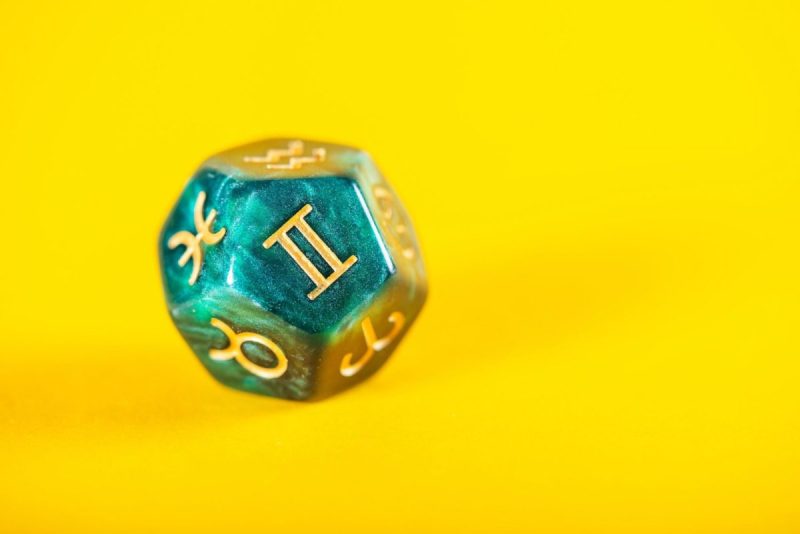 Astrology Dice with zodiac symbol of Gemini May 21 - Jun 20 on Yellow Background