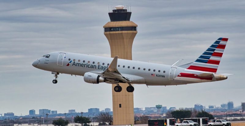 the white, blue, and red airplane Embraer 175 taking off from DFW airport