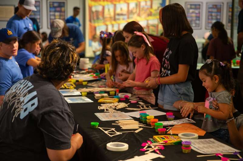 Children attempt to build bridges with craft supplies at a museum