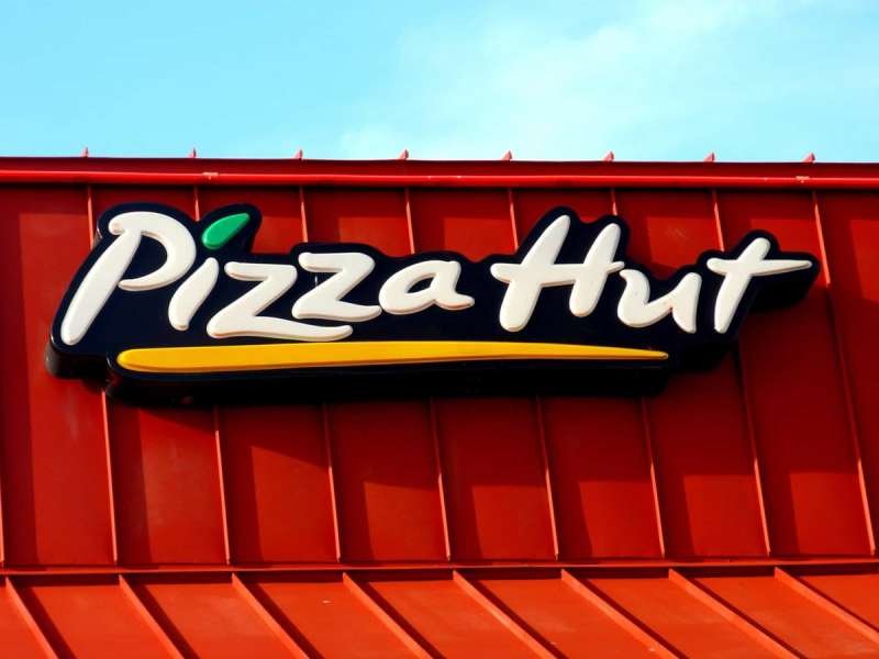 A sign on a restaurant for Pizza Hut, which has partnered with Little Free Library