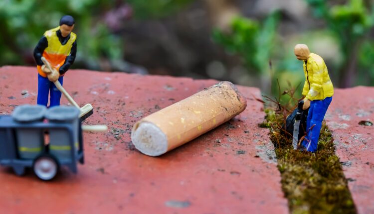 Two small figurines cleaning up trash.