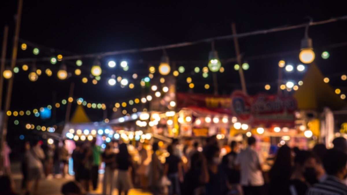Blurred busy fresh market full with crowd people walking in street shopping.