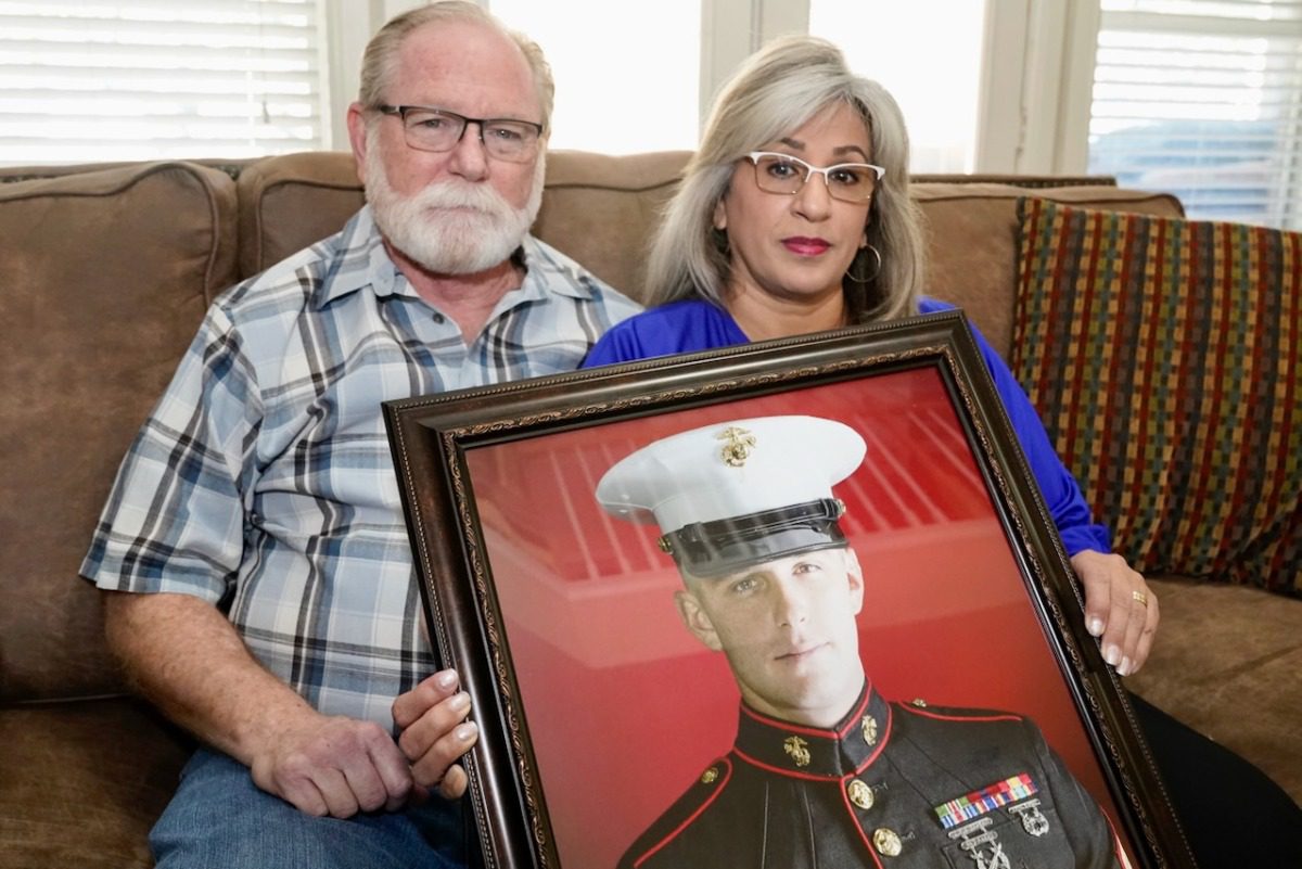 Joey and Paula Reed sitting with photo of son Trevor