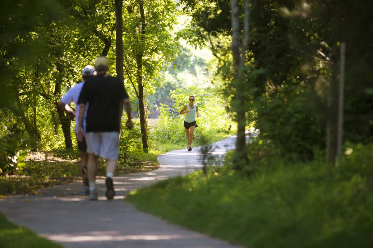 people walk and hike along a shady trail in houston, texas