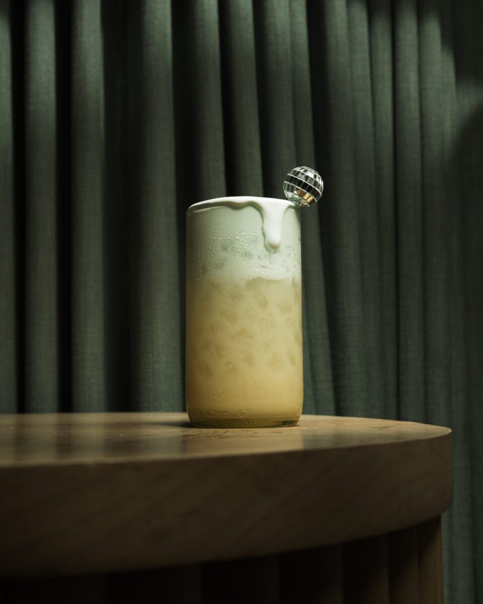 photo of a mocktail with a disco ball toothpick sticking out the top